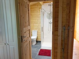 A bathroom with a shower and a toilet at Owl Lodge in Menheniot