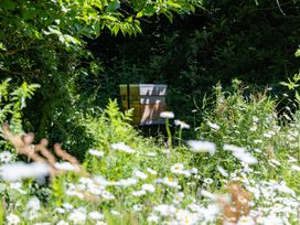 A beehive surrounded by wildflowers at Owl Lodge in Menheniot
