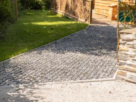 A gravel pathway leading through grass in the garden at Owl Lodge Menheniot
