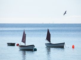 Two boats with sails and buoys in the water at Owl Lodge Menheniot