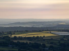 A landscape view of fields and hills in Menheniot at Owl Lodge