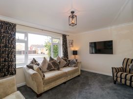 A living room with a sofa, armchair, and television at No 8 Burnham-on-Sea