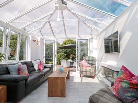 A conservatory with seating area and sliding doors at No 8 Burnham-on-Sea