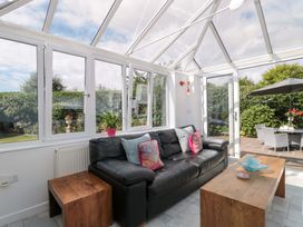 A conservatory with a sofa and coffee table at No 8 Burnham-on-Sea