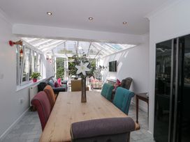 A conservatory with a dining table and seating area at No 8 Burnham-on-Sea