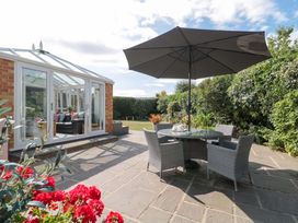 A garden with a table and chairs under an umbrella at No 8 Burnham-on-Sea