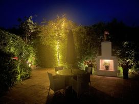 A garden with a table, chairs, and fireplace at No 8 in Burnham-On-Sea