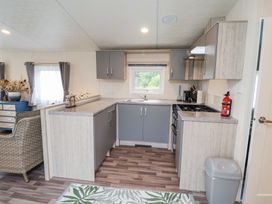 A kitchen with gray cabinets and a gas stove at The Hoot in Great Finborough near Stowmarket