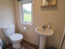 A bathroom with a toilet a sink a mirror and a window at The Hoot in Great Finborough near Stowmarket