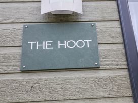 A green rectangular sign with the text THE HOOT mounted on wooden planks at The Hoot in Great Finborough near Stowmarket