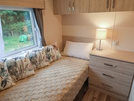 A bedroom with a bed and nightstand at The Hoot in Great Finborough near Stowmarket