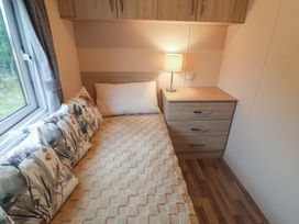 A bedroom with a bed and nightstand at The Hoot in Great Finborough near Stowmarket