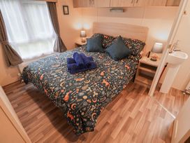 A bedroom with a bed and bedside table at The Hoot in Great Finborough near Stowmarket