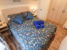 A bedroom with a bed and towels at The Hoot in Great Finborough near Stowmarket