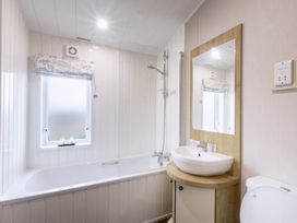 A bathroom with a bathtub, shower, sink, and toilet at Lodge 65 at Riviera Bay Coastal Retreat Brixham