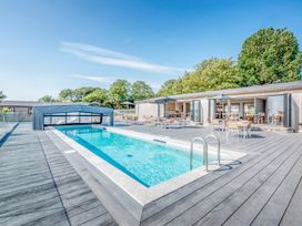 An outdoor area with a pool and seating at Lodge 67 at Riviera Bay Coastal Retreat Brixham