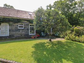 An outdoor area with a tree and chairs at Royal Oak Farm Cottage Betws-y-Coed