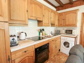 A kitchen with wooden cabinets, appliances and countertop at Royal Oak Farm Cottage Betws-y-Coed