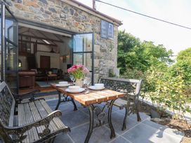 An outdoor seating area with a table and benches at Joe’s Barn in Mullion