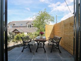 An outdoor seating area with a table and benches at Joe’s Barn in Mullion