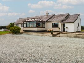 A house with a conservatory and gravel driveway at Tir Mawr in Llanfairpwllgwyngyll