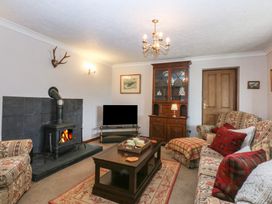 A living room with a fireplace and television at Tir Mawr in Llanfairpwllgwyngyll