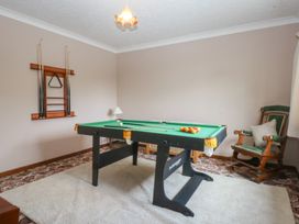 A snug with a pool table and a rocking chair at Tir Mawr in Llanfairpwllgwyngyll