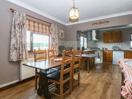 A kitchen with a dining table and chairs at Tir Mawr in Llanfairpwllgwyngyll