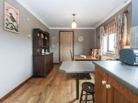 A kitchen with a dining table and chairs at Tir Mawr in Llanfairpwllgwyngyll