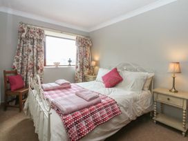 A bedroom with a bed and nightstand at Tir Mawr in Llanfairpwllgwyngyll
