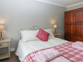 A bedroom with a bed and nightstands at Tir Mawr in Llanfairpwllgwyngyll