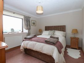 A bedroom with a double bed and furniture at Tir Mawr in Llanfairpwllgwyngyll