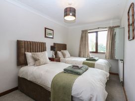 A bedroom with twin beds and a window at Tir Mawr in Llanfairpwllgwyngyll