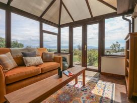 A conservatory with a sofa and coffee table at Tir Mawr in Llanfairpwllgwyngyll