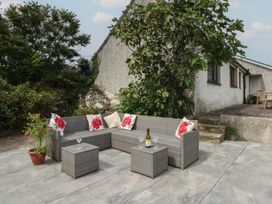 An outdoor patio with a sofa set and table at Tir Mawr in Llanfairpwllgwyngyll