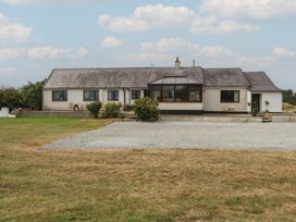 A house with a gravel drive and plants at Tir Mawr in Llanfairpwllgwyngyll