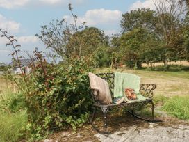 A bench with blankets and a book in an outdoor area at Tir Mawr in Llanfairpwllgwyngyll