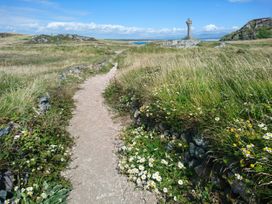 A path leading to a cross in a grassy area at Tir Mawr in Llanfairpwllgwyngyll