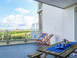 A balcony with chairs and a table at 4 Ocean Gate in Newquay