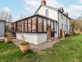 A conservatory with large windows and plants at Pencestyll in Cardigan