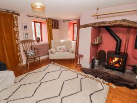 A living room with a fireplace and seating area at Pencestyll Cardigan