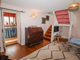 A hallway with a staircase and chest of drawers at Pencestyll in Cardigan