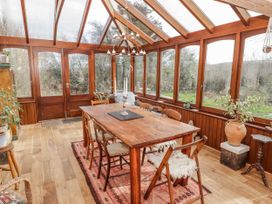A dining area with a wooden table and chairs at Pencestyll in Cardigan