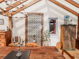 A dining room with a wooden table candle holder and decorative cabinet at Pencestyll, Cardigan