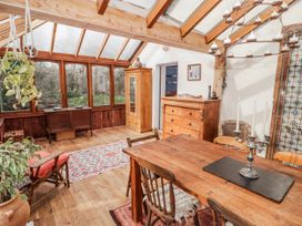 A conservatory with a wooden table and chairs at Pencestyll in Cardigan