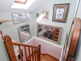 An interior hallway with staircase and mirrors at Pencestyll, Cardigan