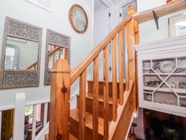A hallway with staircase and mirrors at Pencestyll in Cardigan