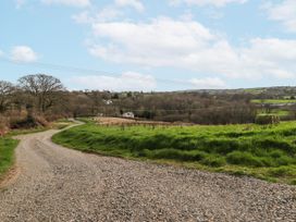 A winding gravel road through a rural landscape at Pencestyll in Cardigan