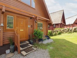 An exterior view of a wooden lodge with a front door at Thistle Dubh ('Doo') Sandyhills