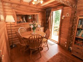 A dining room with a table and chairs at Thistle Dubh ('Doo') Sandyhills